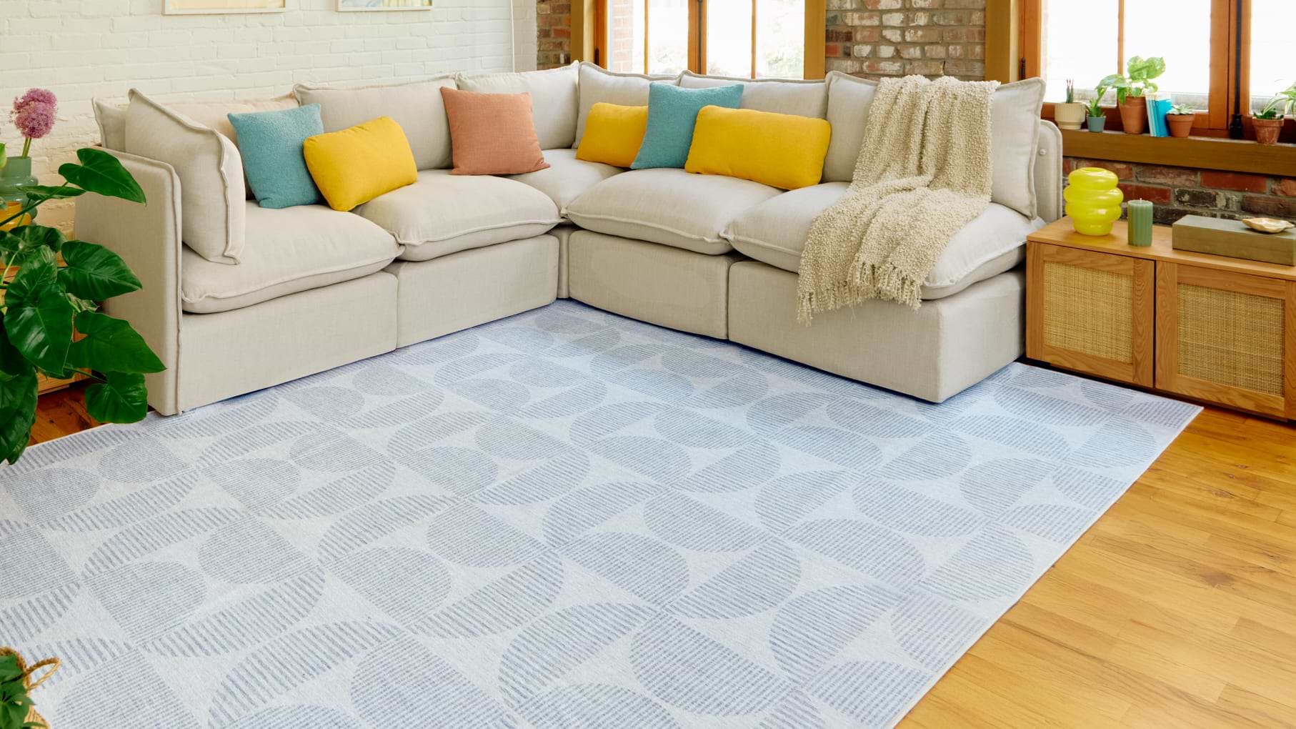 White rug with light blue pattern and Gaia sectional.