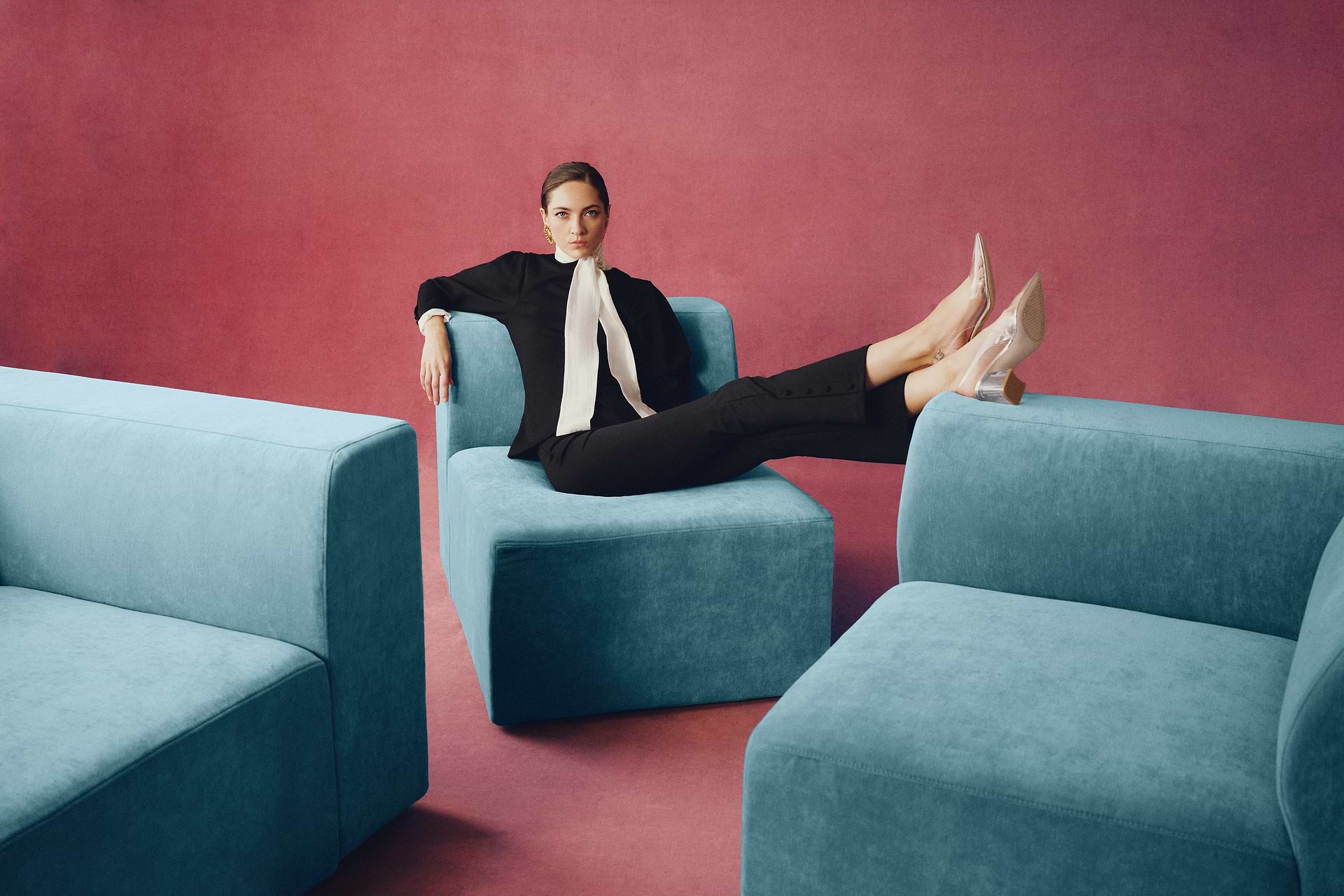 Woman lying on blue modular sofa