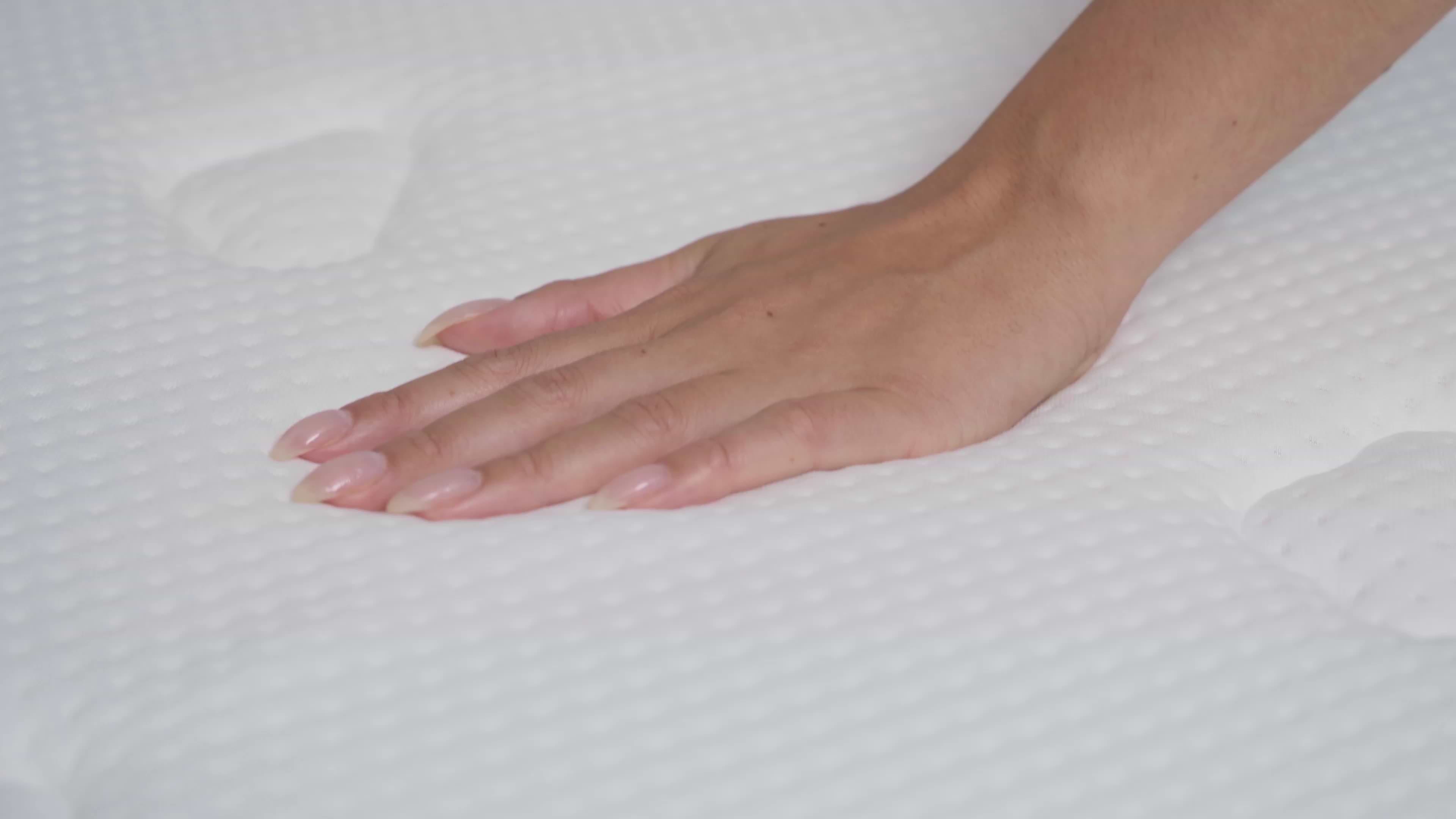 Main appuyant sur la surface d'un matelas mi-ferme